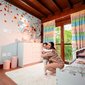Mãe abraçando filha em quarto decorado, ilustrando inspirações de cores para quarto de bebê