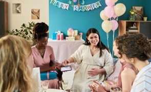 Gestante com amigas em decoração leve, inspirando como organizar um chá de fraldas Gestante com amigas em decoração leve, inspirando como organizar um chá de fraldas