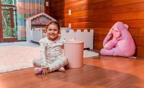 Cesto de roupa para bebê em quarto infantil organizado com criança ao lado